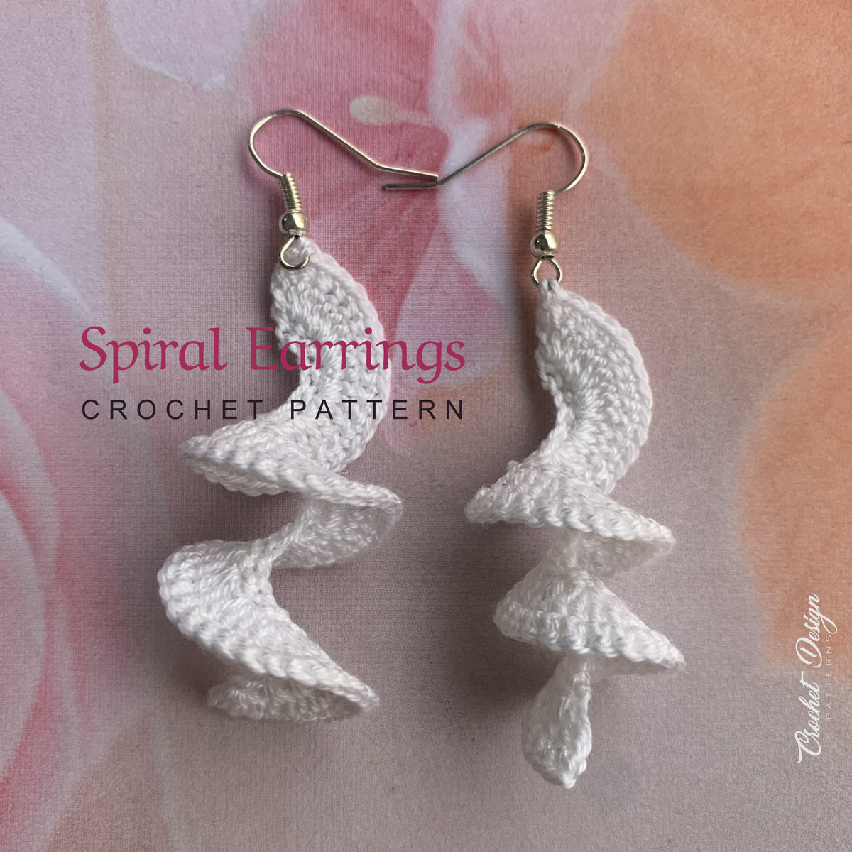 Crochet spiral earrings on floral fabric, side angle view